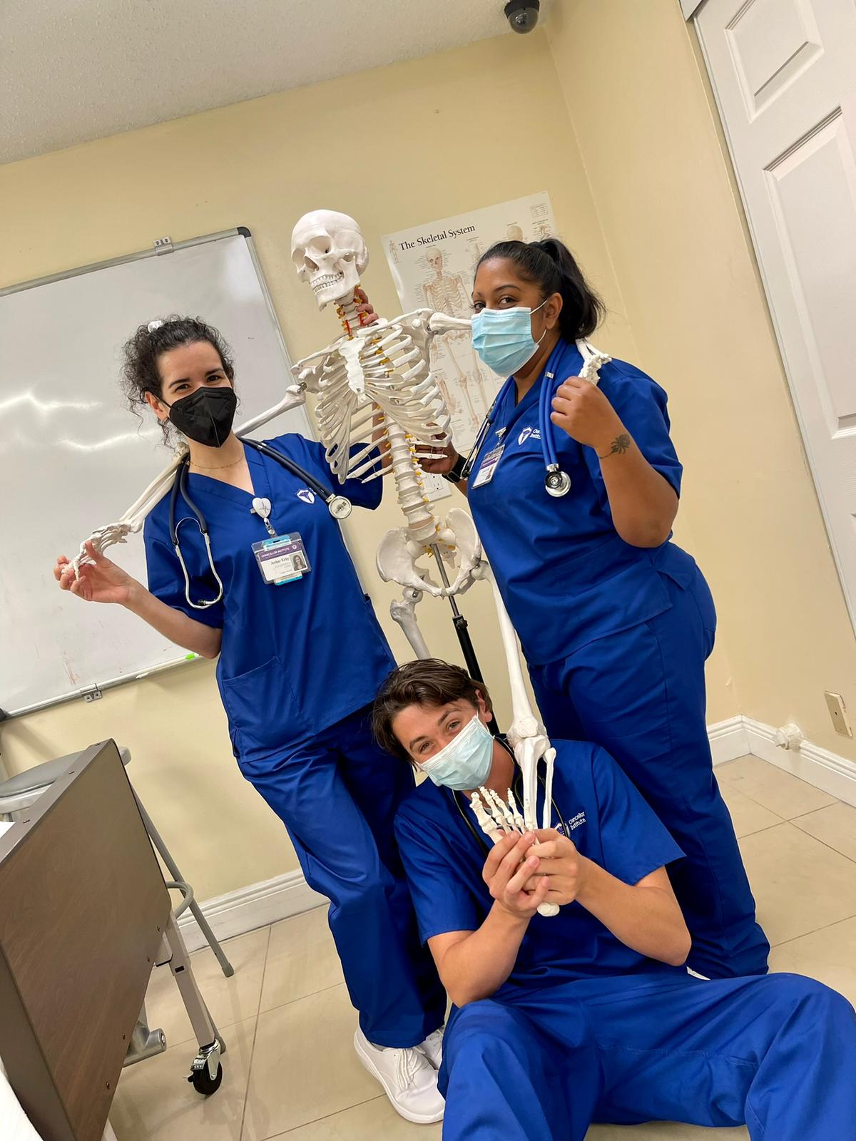 Nursing students having fun with a skeleton model at Chancellor Institute