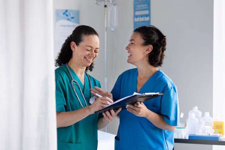 Two smiling nursing students taking notes at Chancellor Institute