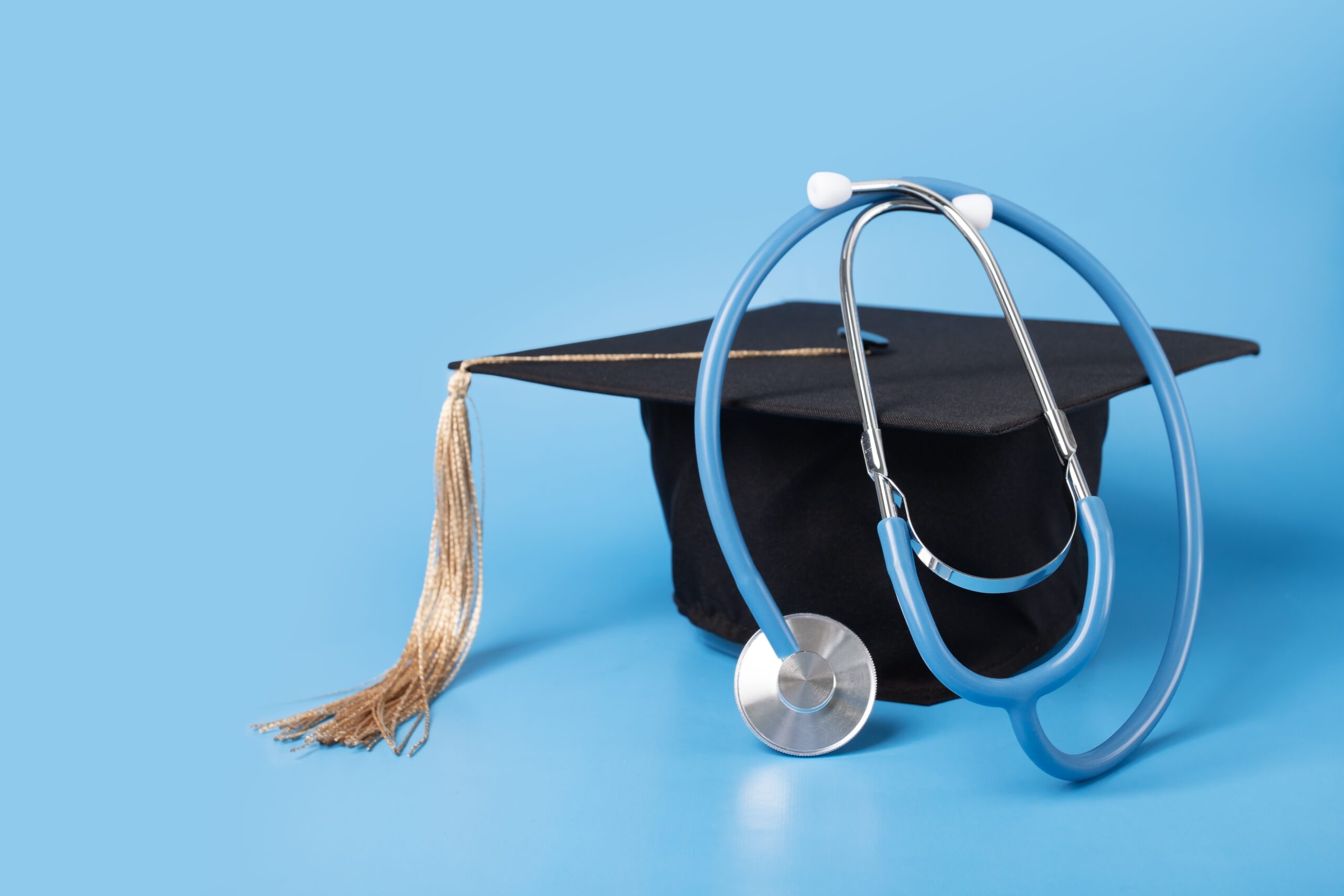 Stethoscope placed on a graduation cap symbolizing nursing education success at Chancellor Institute