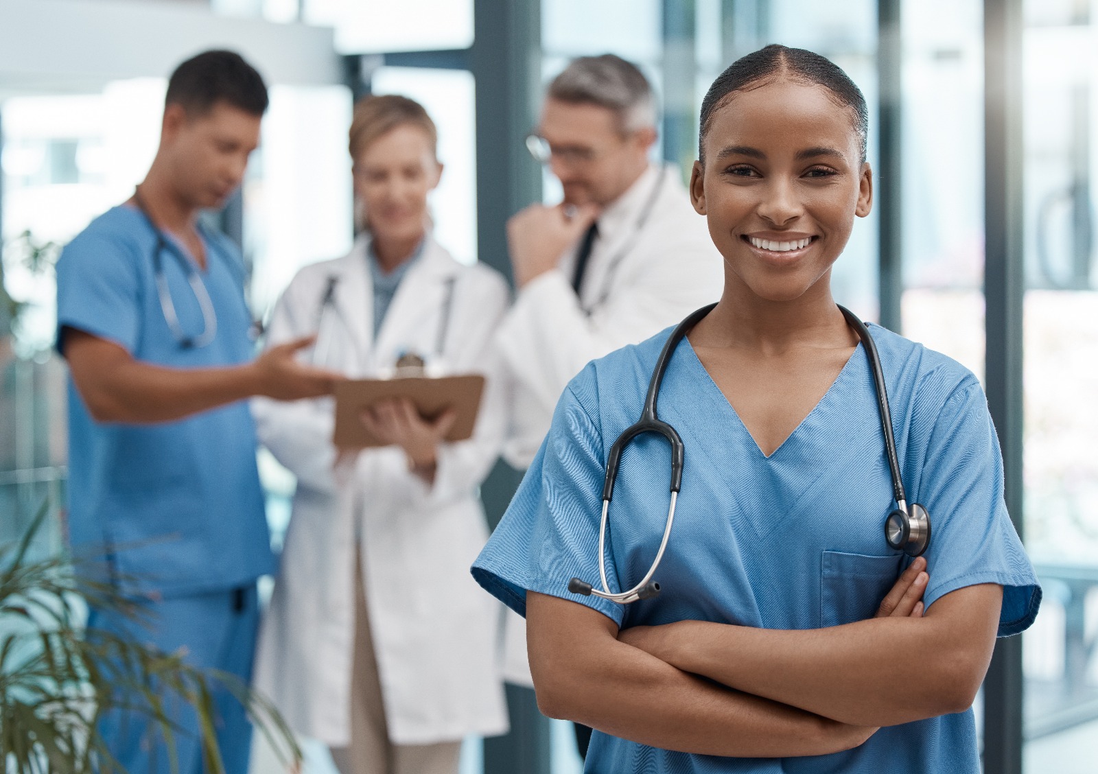 Nursing student at Chancellor Institute smiling while faculty and peers discuss in the background